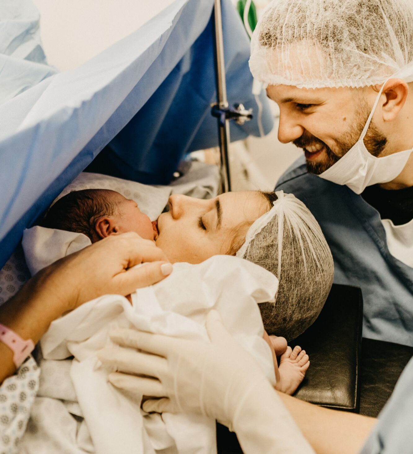 Mother kissing her newborn in the hospital delivery room